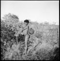 Boy returning to the werft from a waterhole, using a carrying stick to carry an animal stomach water bag