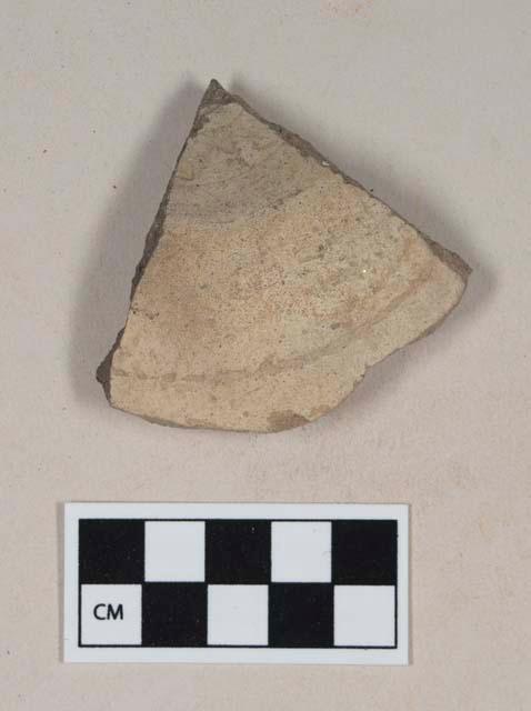 Coarse gray bodied earthenware base sherd, with buff slip