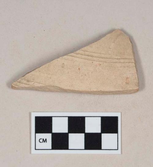 Coarse red bodied earthenware body sherd, with buff slip and incised lines