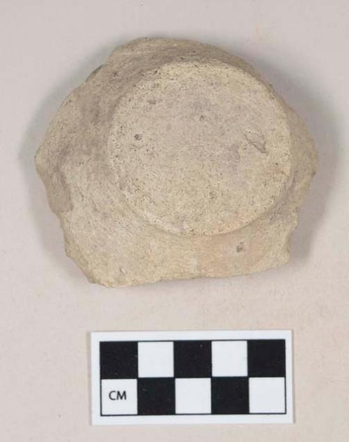 Coarse buff bodied earthenware base sherd, with buff slip