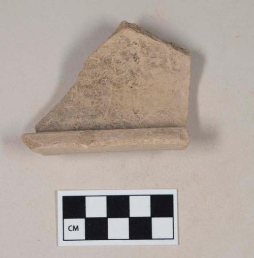 Coarse buff bodied earthenware rim sherd, with buff slip