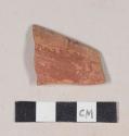 Red bodied earthenware rim sherd, with red slip and black slipped stripes