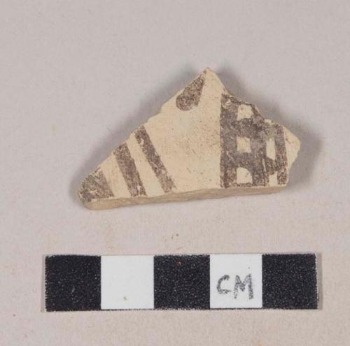 Buff bodied earthenware body sherd, with buff slip and brown slipped decoration