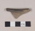 Red bodied earthenware rim sherd, with brown slip, wheel thrown