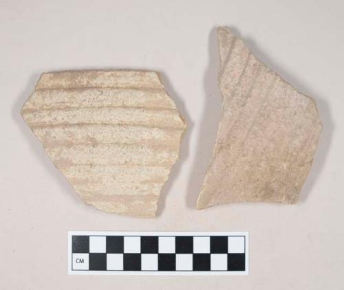 Molded coarse buff bodied earthenware body sherd, with buff slip