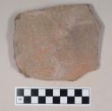 Coarse red bodied earthenware body sherd, unslipped, with blackened interior, reduced core