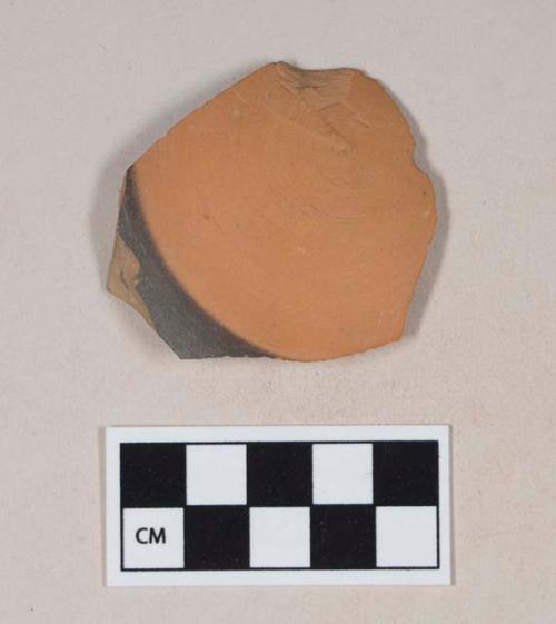 Red bodied earthenware base sherd, with red and black slip, wheel thrown