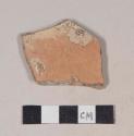 Red bodied earthenware body sherd, with red and buff slip, reduced core