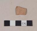 Red bodied earthenware rim sherd, with red slip, wheel thrown