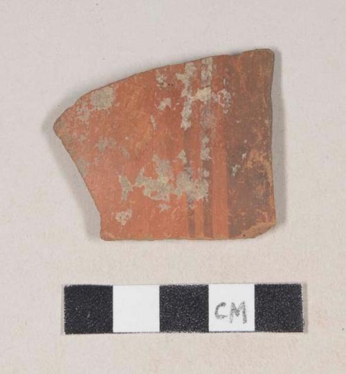 Red bodied earthenware rim sherd, with red slip and brown slipped stripes, wheel thrown