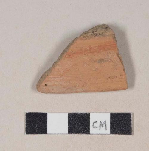 Coarse red bodied earthenware rim sherd, with red slip and red slipped stripes, reduced core