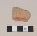 Red bodied earthenware body sherd, with red slipped stripe and buff slipped interior