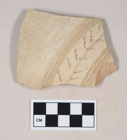 Coarse red bodied earthenware body sherd, with buff slip and incised or combed designs