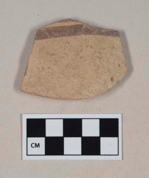 Coarse buff bodied earthenware body sherd, with buff slip and brown slipped stripes