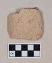 Coarse red bodied earthenware rim sherd, with buff slip, reduced core