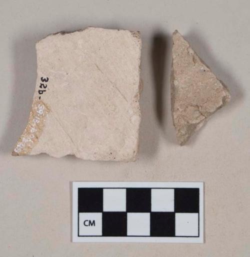 Coarse gray bodied earthenware body sherds, with white slip, possible scratched lines; two sherds crossmend