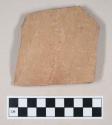 Coarse red bodied earthenware body sherd, unslipped, with incised lines