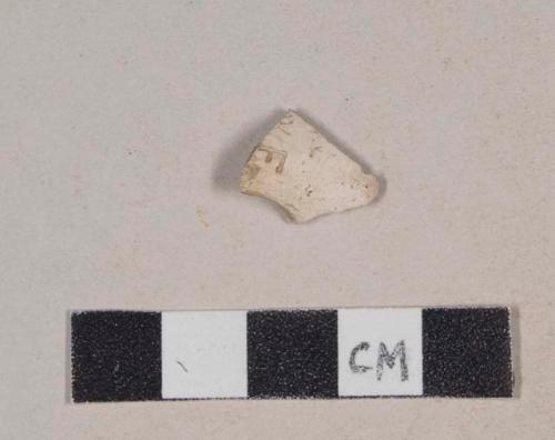 Unsmoked pipe bowl fragment, with incised letters and design