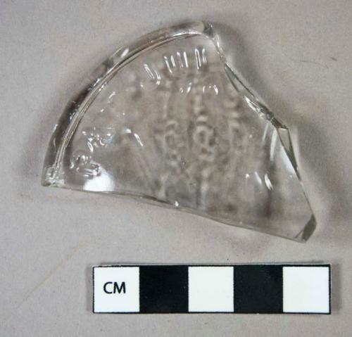 Glass, colorless mold-blown bottle base fragment; includes partial maker's mark