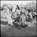 Group of women sitting, with Kernel Ledimo leaning over one of them