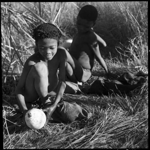 /Qui (son of "/Gao Music") holding an ostrich eggshell filled with water