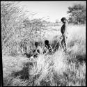 "≠Gao Lame" standing, and two unidentified boys sitting, at the edge of a waterhole