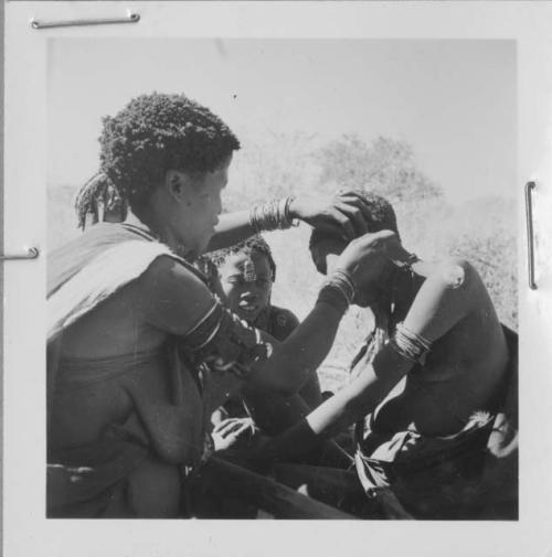 Woman fixing another woman's earring