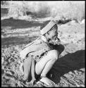 /Naoka (wife of "Gao Medicine") wearing an ostrich eggshell headband, squatting