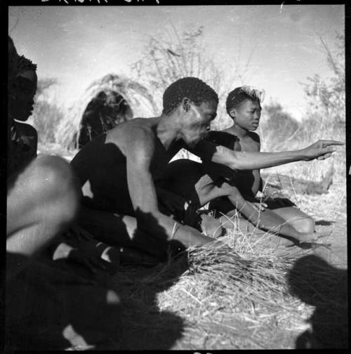 "Gao Medicine" playing !ó'm!hú / !’Om g!xuni / ’Ai kota !U!u g!xuni / N!aih //’an (the porcupine game, also known as the axe game, assegai game or war game) with a group of men and boys, close-up