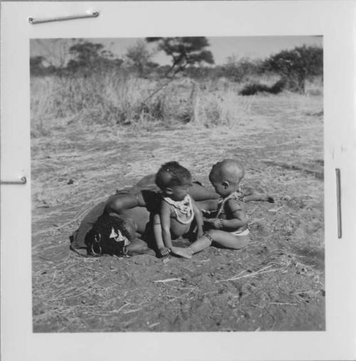 !Ungka (≠Toma's sister) lying down, with her baby, Sa≠gai, and !Ungka Norna sitting next to her