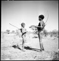 Two boys standing and holding bows and arrows