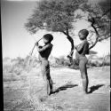 Two boys standing and holding bows and arrows