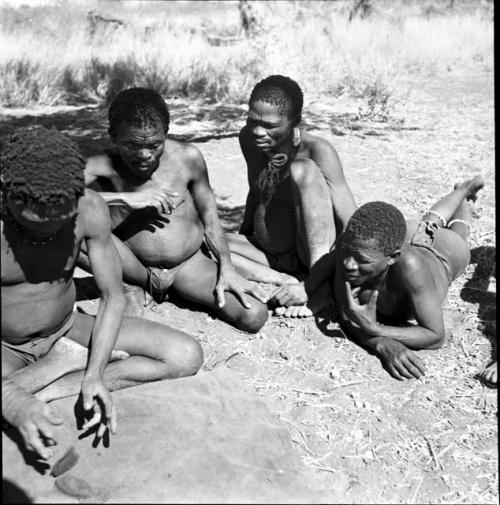 Group of men throwing and reading oracle disks, including "Gao Hunchback" and ≠Gao (husband of Khwo//o-/Gasa)