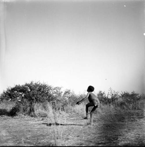 Boy tossing a djani (helicopter toy / winged toy made from a hollow reed)