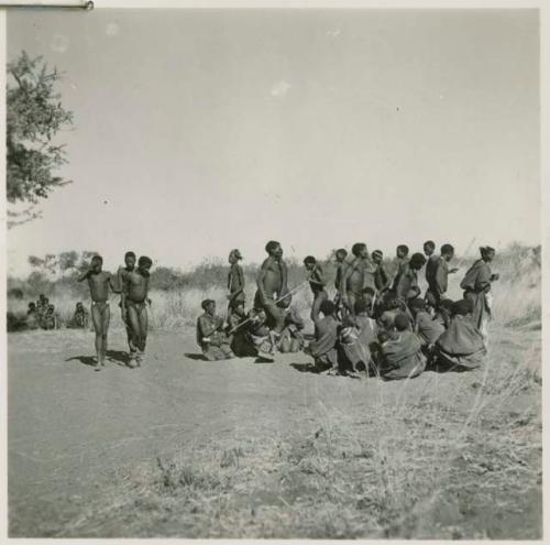 Group of people dancing, with three medicine men in early stages of trance