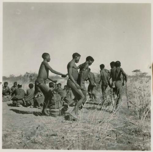 Men dancing, including "/Gao Music" being held by other men who also appear to be in partial trance