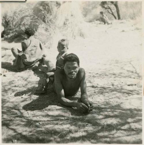 "Gao Medicine" lying down, with his son, /Gaishay, sitting on his back