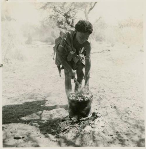 /Naoka ("Gao Medicine's" wife) cooking a pot full mangetti nuts on a fire