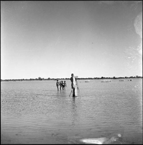 Girls playing in the water of Gautscha Pan, with John Marshall filming them, distant view