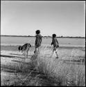 Girls walking along the edge of Gautscha Pan with water in it