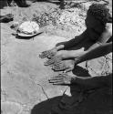 /Naoka (wife of "Gao Medicine) and a man putting their hands on a kaross