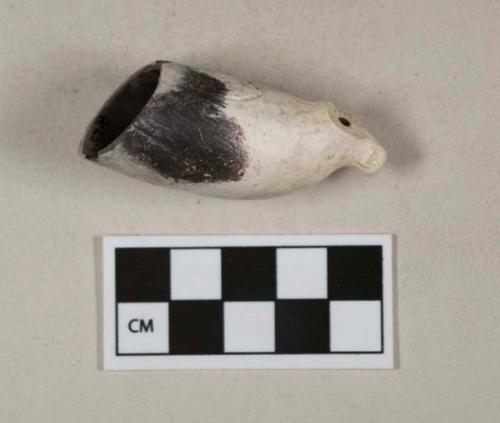 White kaolin pipe bowl fragment, burned, Cartouche stamp with "T.D.," embossed with "T.D." on either side of foot