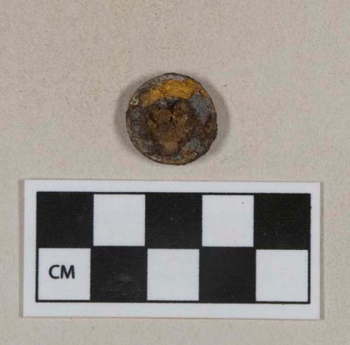 Ferrous metal button fragment, heavily corroded