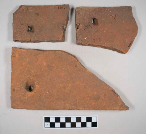 Red ceramic rooftile fragments with nail holes