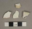 Undecorated whiteware vessel body and rim fragments, white paste