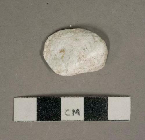 White shell fragment, heavily corroded, likely oyster