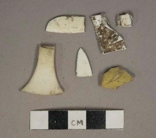 White plastic fragments, 1 wrapper fragment, 1 gold plastic fragment