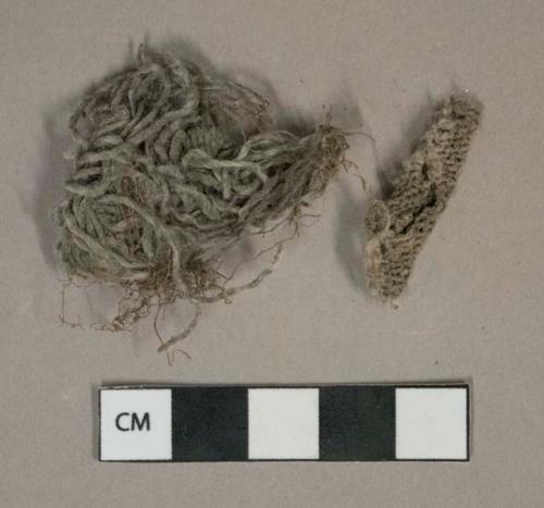 White or tan cotton woven fabric fragment and likely tassle fragment