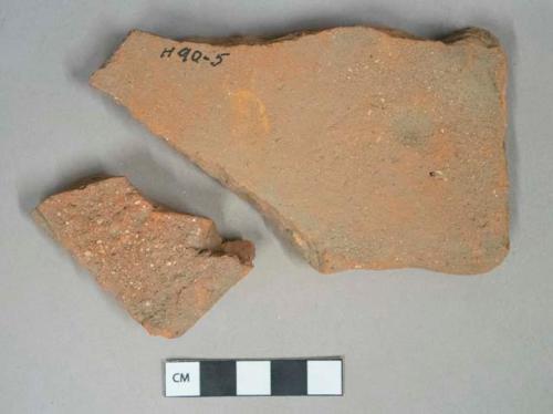 Red ceramic rooftile fragments, 1 with nail hole, 1 with fingerprints