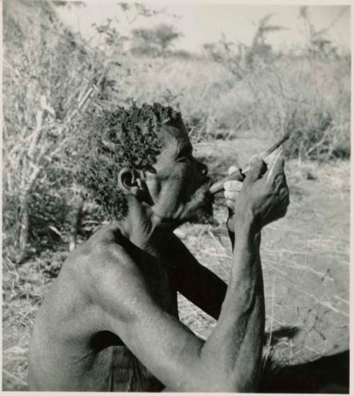 "Old /Gaishay" pushing tobacco down his pipe, profile